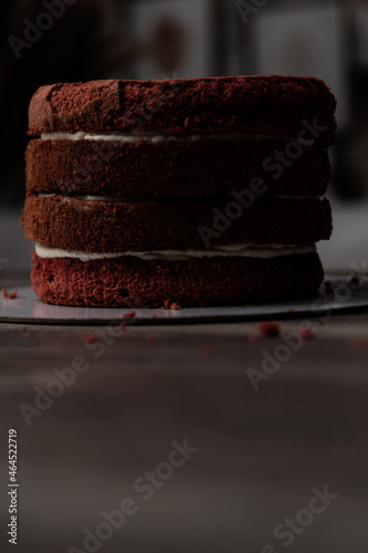 Chef or baker decorating cake with white whipped cream.Soft fokus photo