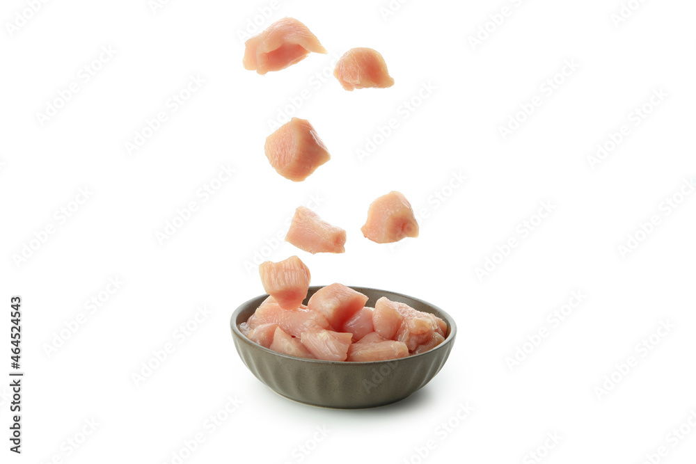 Raw chicken fillet slices falling in bowl, isolated on white background Raw chicken fillet slices falling in bowl, isolated on white background