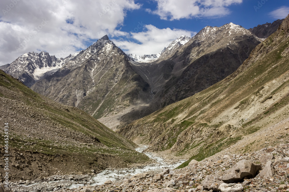 Beautiful landscape of snow capped Himalayan mountain peaks rising above a remote valley on the trekking route from Manali to Padum in Zanskar in India.
