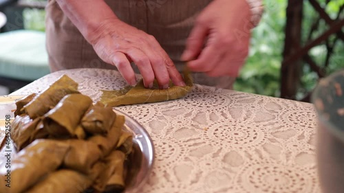 People cook dolma food.
Grape leaves stuffed with minced meat. photo