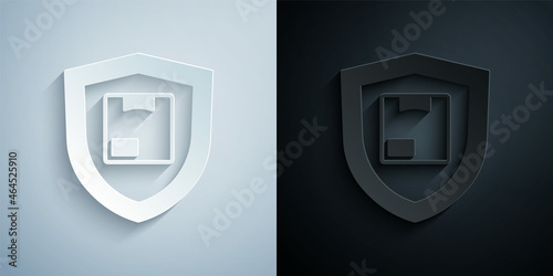 Paper cut Delivery security with shield icon isolated on grey and black background. Delivery insurance. Insured cardboard boxes beyond the shield. Paper art style. Vector