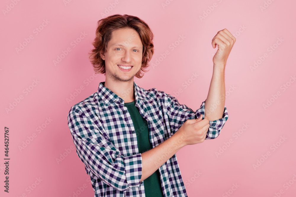 Photo of young handsome man happy positive smile correct fix sleeves shirt isolated over pink color background Photo of young handsome man happy positive smile correct fix sleeves shirt isolated over pink color background