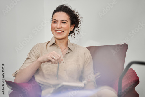 Female therapist sitting and making notes while consulting her patients photo