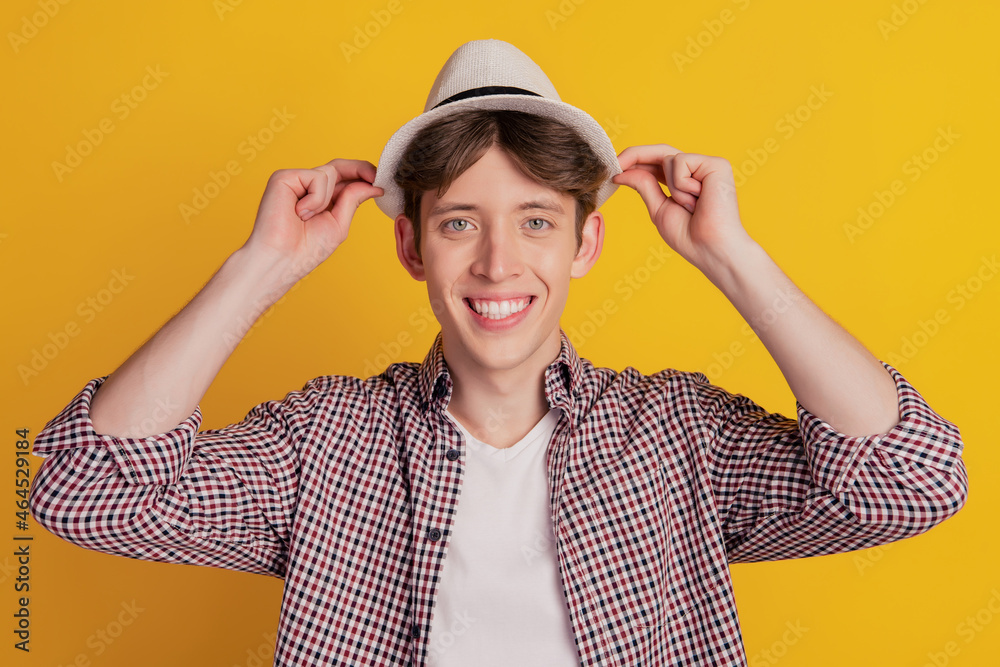 Photo of young cheerful man happy positive smile wear hat summer trip travel isolated on yellow color background Photo of young cheerful man happy positive smile wear hat summer trip travel isolated on yellow color background