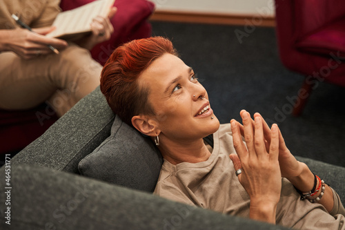 Woman laying on couch during her therapy session and gesturing while telling something