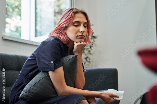 Young female patient looking away with hope while sitting at her psychotherapist