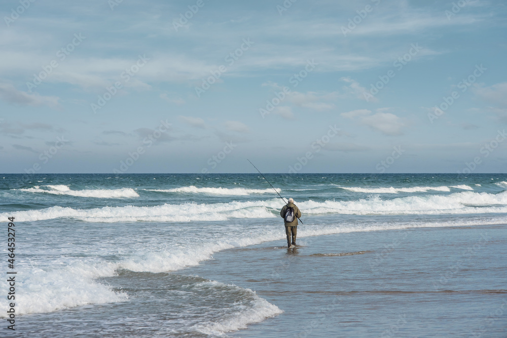 senior fishing with surfcasting technique on the beach