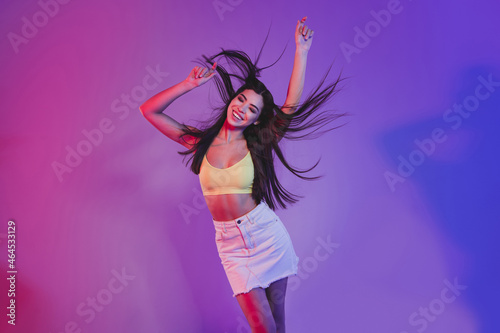 Portrait of attractive cheerful dreamy girl dancing posing chill isolated over vivid violet purple neon color background