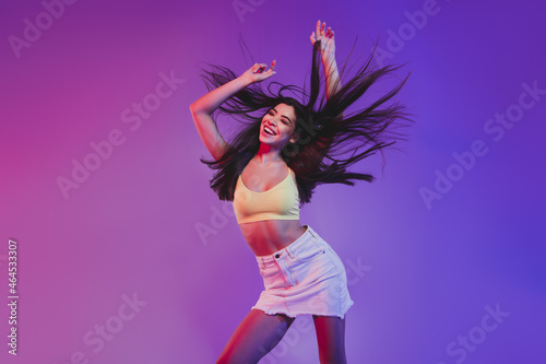 Fototapeta Naklejka Na Ścianę i Meble -  Portrait of attractive cheerful carefree girl dancing clubbing isolated over vivid violet purple neon color background