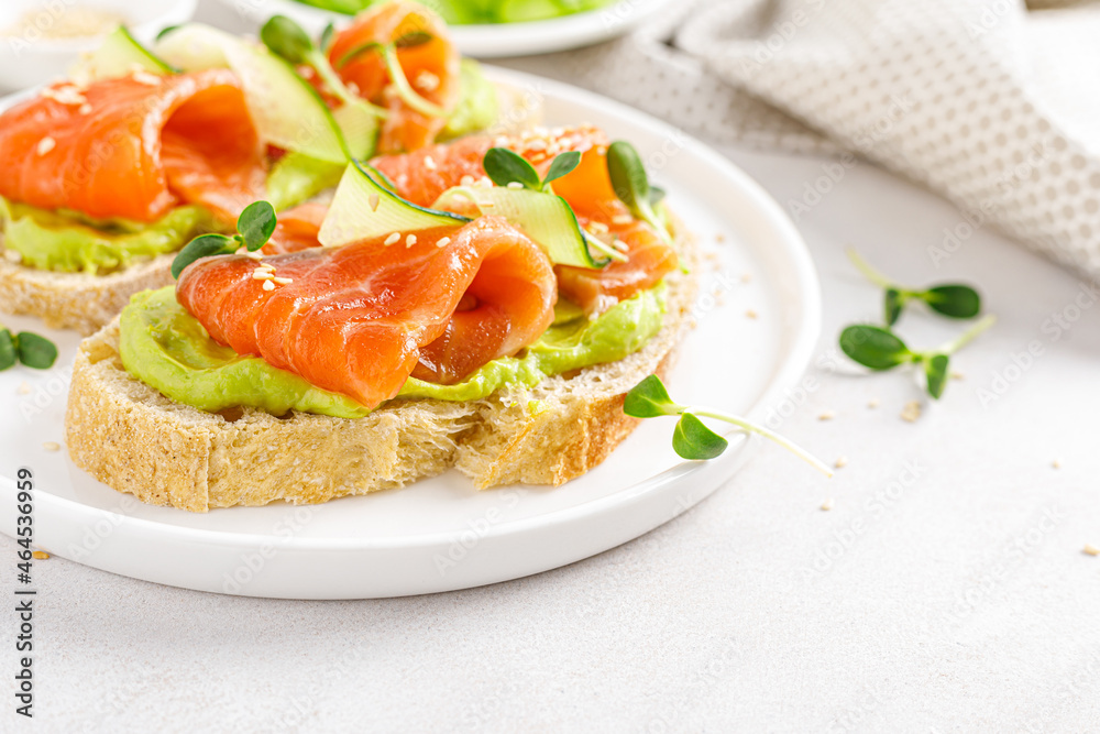 Open sandwiches with salted salmon, guacamole avocado and microgreens. Seafood. Healthy food. Open sandwiches with salted salmon, guacamole avocado and microgreens. Seafood. Healthy food.