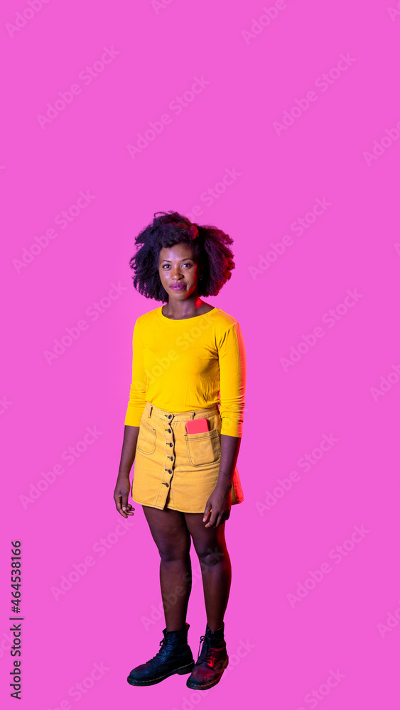 Young black woman posing isolated staring friendly and relaxed smiling positive on pink background Young black woman posing isolated staring friendly and relaxed smiling positive on pink background
