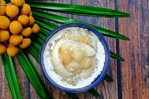 Sweet sticky rice with longan and coconut sliced in coconut milk (Kao niao piak lumyai). Authentic Thai dessert. photo