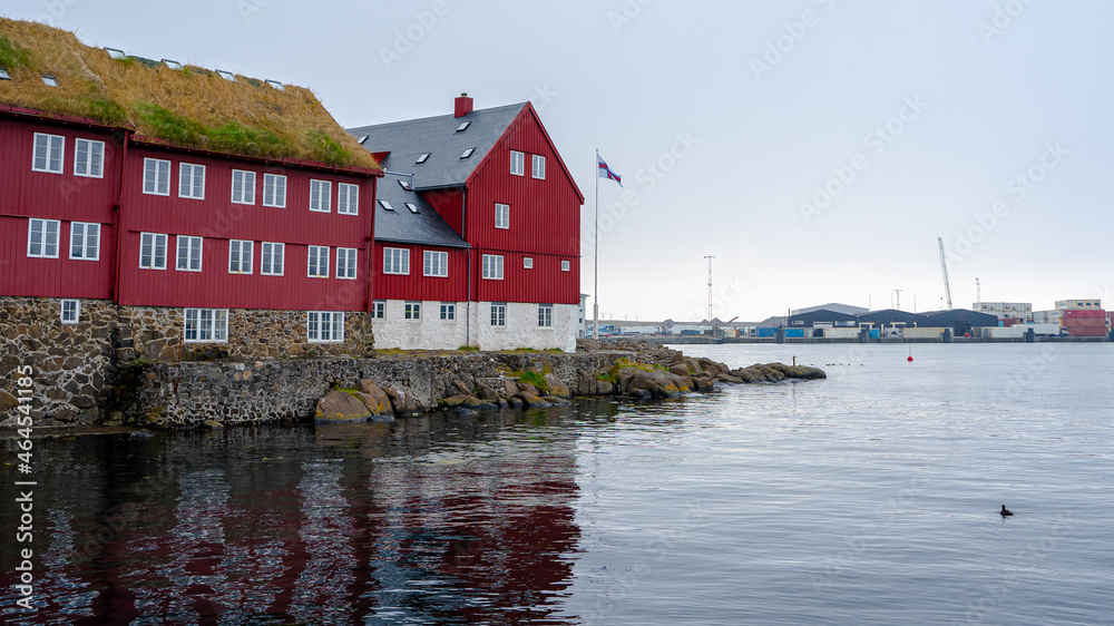 View of the beautiful Faroe Islands Flag in the city of Torshavan in the Governments red building with grass on the roof View of the beautiful Faroe Islands Flag in the city of Torshavan in the Governments red building with grass on the roof