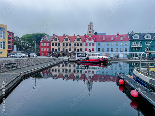 View of the beautiful city of Torshavan in the Faroe Islands and its clausal colorful houses, red building Goverment with grass on the roof , and marina. photo