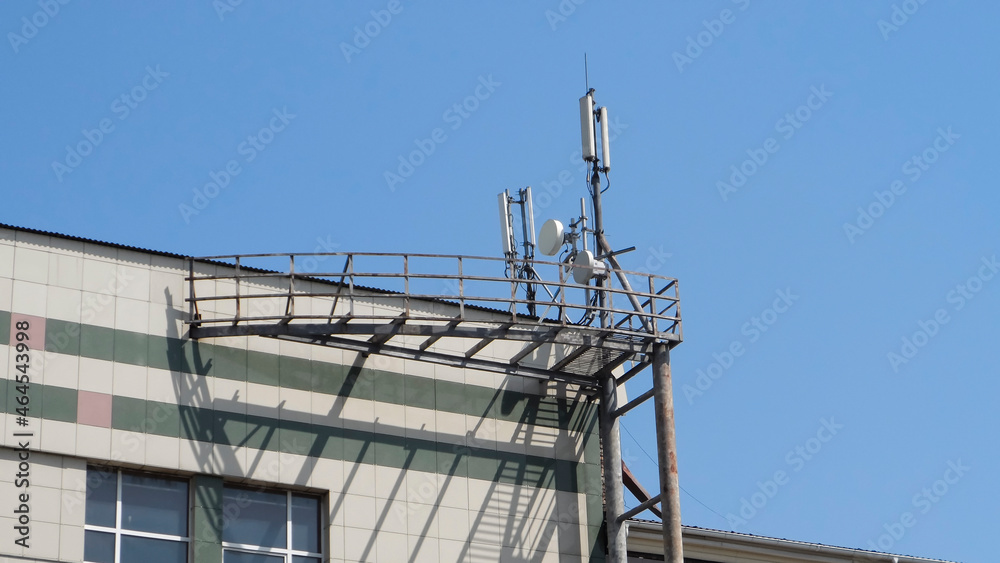 Cellular network antenna. Mobile telephone radio network antennas on the building roof.

