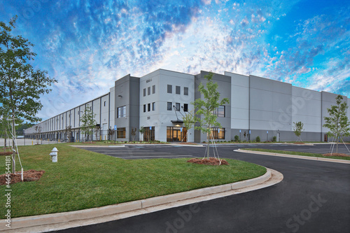 Modern gray warehouse distribution facility under gorgeous cloudy sky