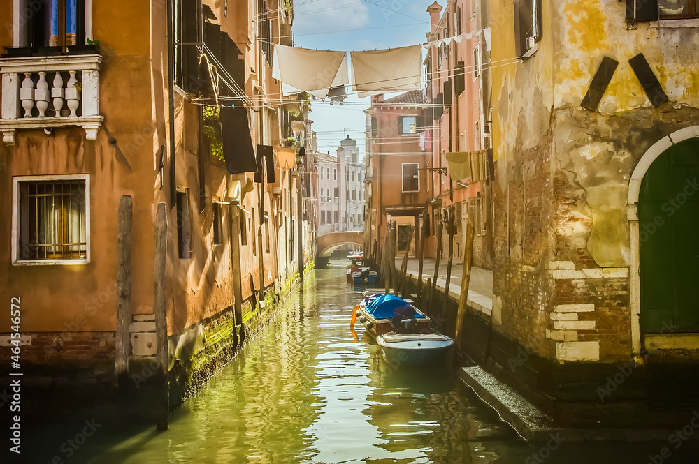 Small canal with clothes hung over the canal, with moored boats, old houses and Venetian lagoon, Venice, UNESCO world heritage site, Veneto, Italy, Europe.