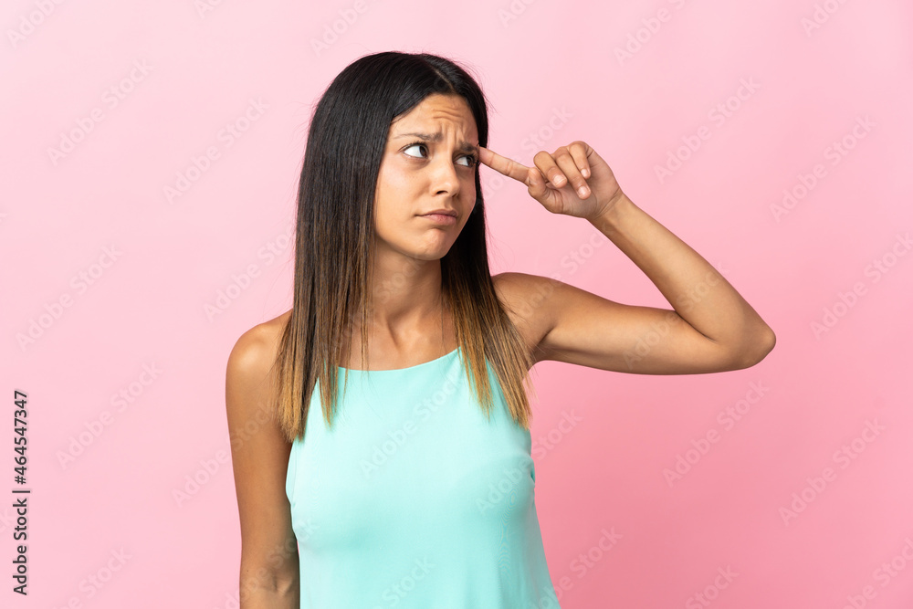 Caucasian girl isolated on pink background making the gesture of madness putting finger on the head Caucasian girl isolated on pink background making the gesture of madness putting finger on the head