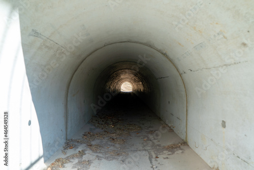 A dimly lit concrete tunnel passage.
