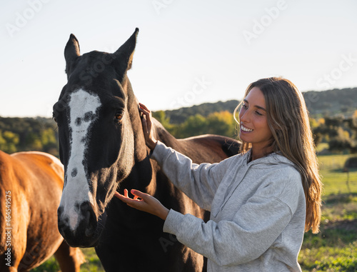 Young woman with her horse in evening sunset light