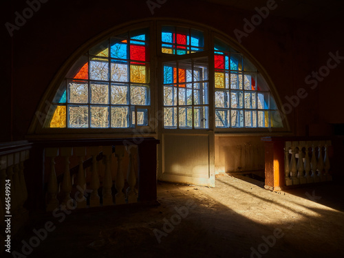 Mosaic window in an old abandoned country house  twilight  a ray of light.