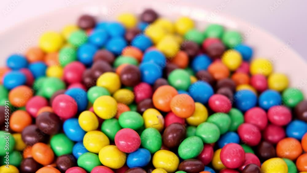 Frankfurt, Germany, October 2021: close-up of multi-colored button-shaped chocolates, each of which has letter Frankfurt, Germany, October 2021: close-up of multi-colored button-shaped chocolates, each of which has letter