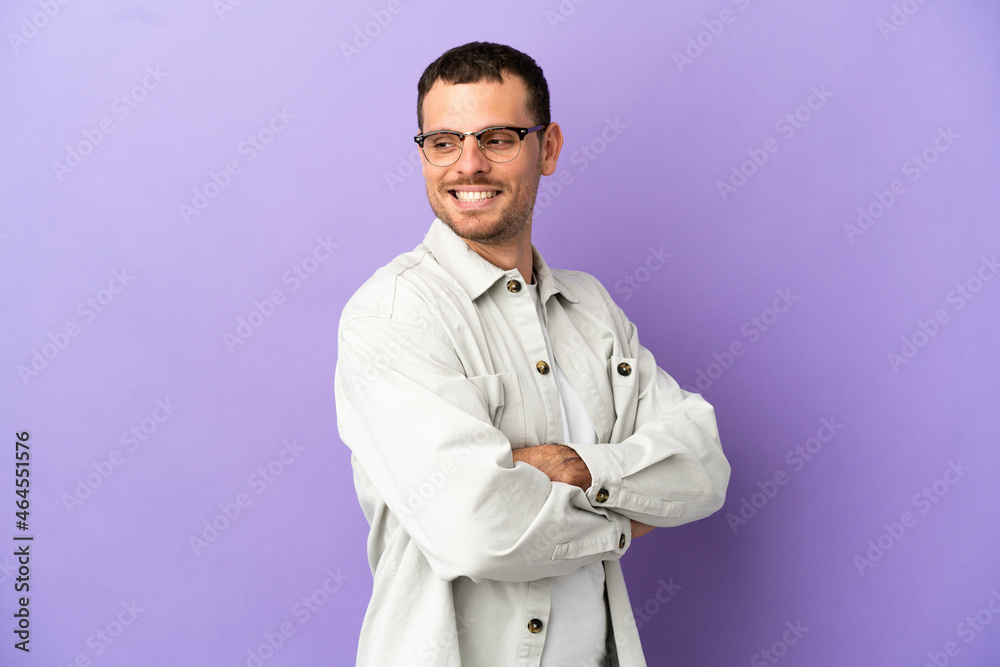 Brazilian man over isolated purple background looking to the side and smiling Brazilian man over isolated purple background looking to the side and smiling