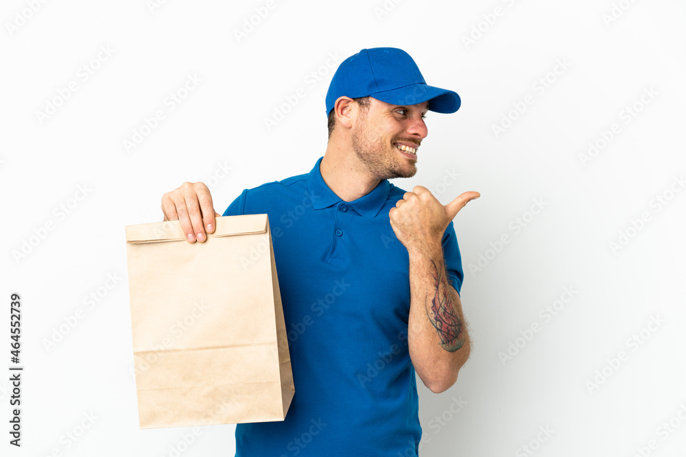 Brazilian taking a bag of takeaway food isolated on white background pointing to the side to present a product Brazilian taking a bag of takeaway food isolated on white background pointing to the side to present a product