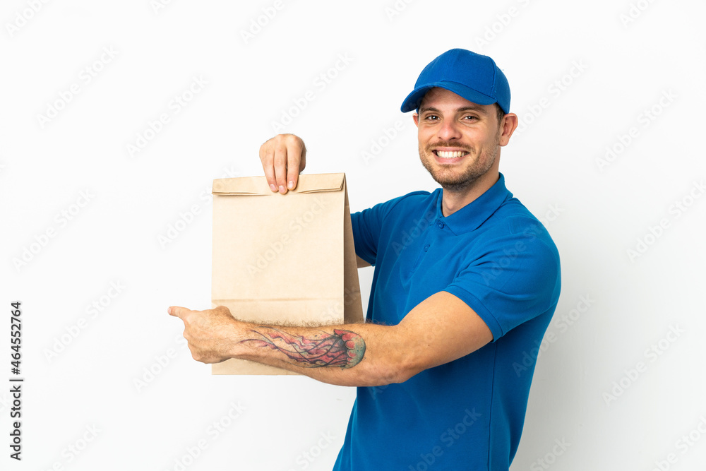 Brazilian taking a bag of takeaway food isolated on white background pointing back Brazilian taking a bag of takeaway food isolated on white background pointing back