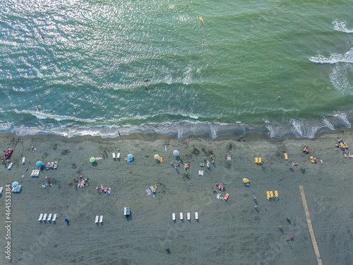 Drone view of the beach with vacationers on the black magnetic sands in Georgia. Aerial photography, black sand beach, waves, island, lifestyle, people. Coastline photo