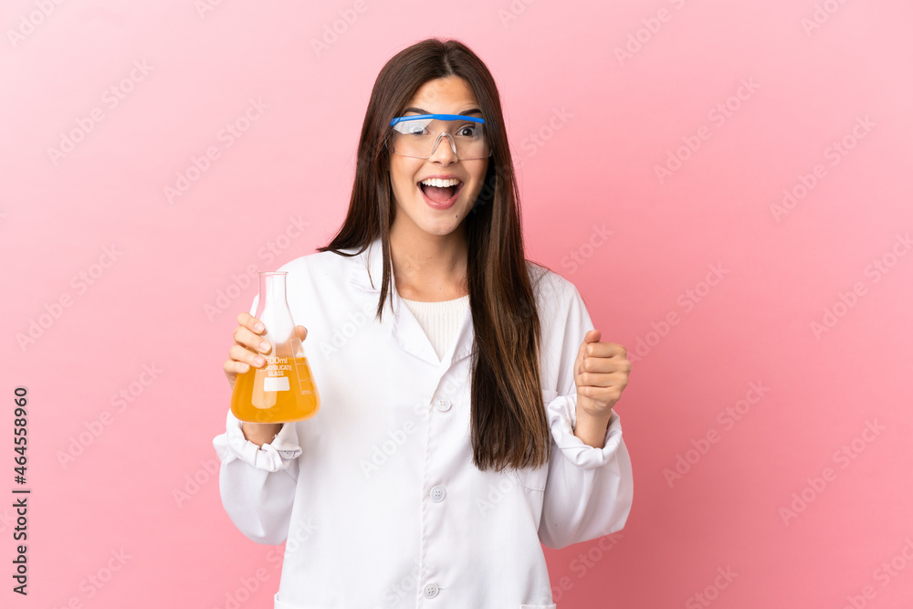 Young scientific girl over isolated pink background celebrating a victory in winner position Young scientific girl over isolated pink background celebrating a victory in winner position