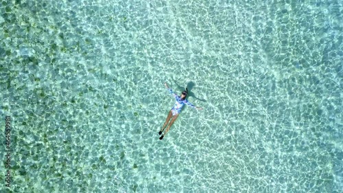 Top down view of a girl floating in a lagoon