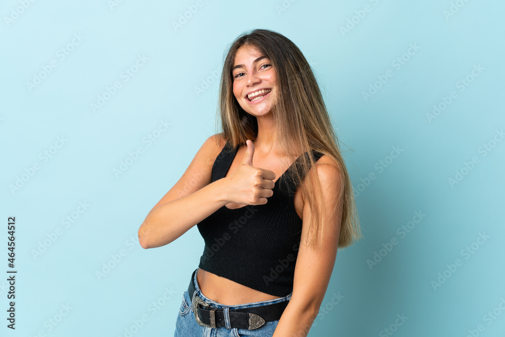 Young caucasian woman isolated on blue background giving a thumbs up gesture Young caucasian woman isolated on blue background giving a thumbs up gesture