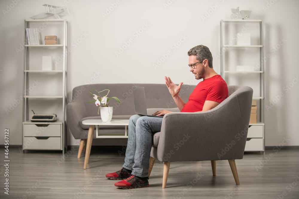 adult man in glasses working on computer sitting in chair, freelance adult man in glasses working on computer sitting in chair, freelance