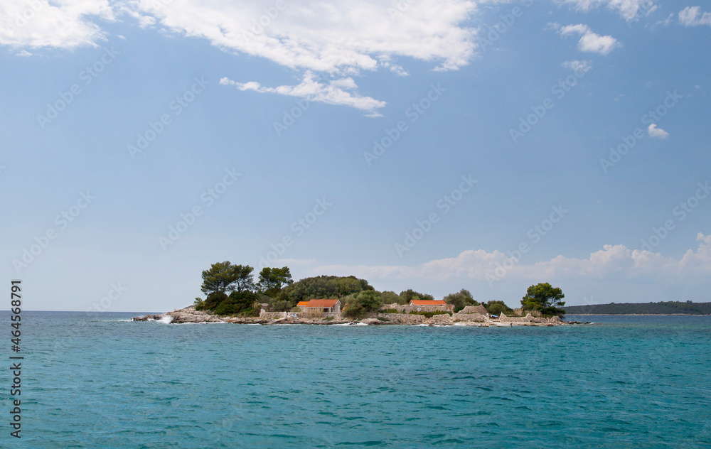 A small lonely island with a house and a dock in the sea A small lonely island with a house and a dock in the sea