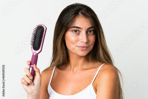 Young caucasian woman isolated on white background with hair comb