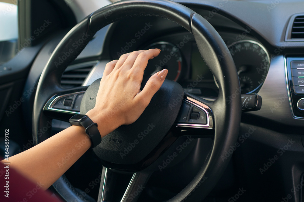 Close up of woman hand pressing the horn button while driving a car. aggressive driver using horn