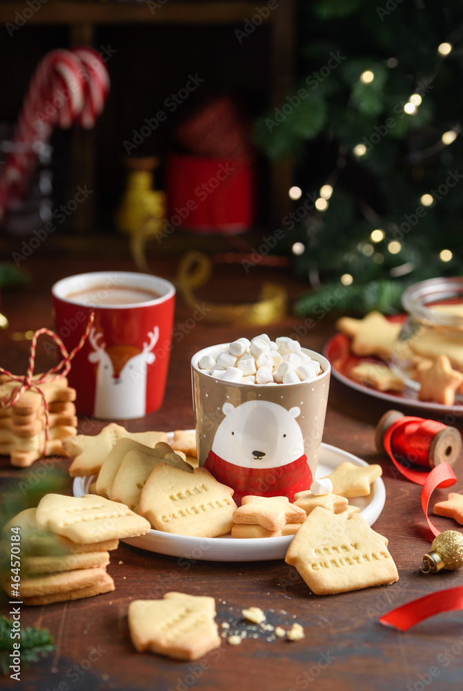 Children's сhristmas shortbread cookies with cocoa mug on a wooden table. Festive cookies with the words 