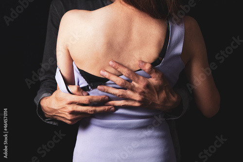 a man sexually takes off a woman's clothes © S...