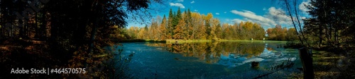 Panorama of autumn lake. Mirror reflection in water, blue sky. © mikhailgrytsiv
