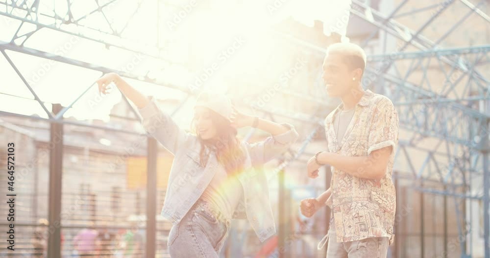 Move your body. Portrait shot of handsome multiracial man and his caucasian girlfriend dancing at the street of town center at sunlight. Students, urban life concept Move your body. Portrait shot of handsome multiracial man and his caucasian girlfriend dancing at the street of town center at sunlight. Students, urban life concept