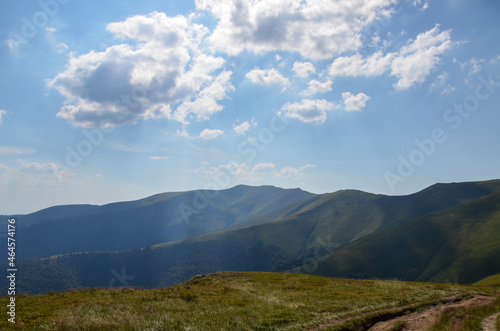 Amazing sunny landscape with grass green hills at Carpathian mountains under blue sky. Borzhava ridge, Ukraine