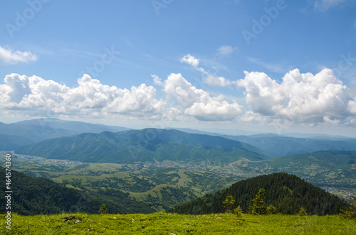 Beautiful view from the mountain ridge to the village in the valley near Carpathian mountains at the summer day. Ukraine