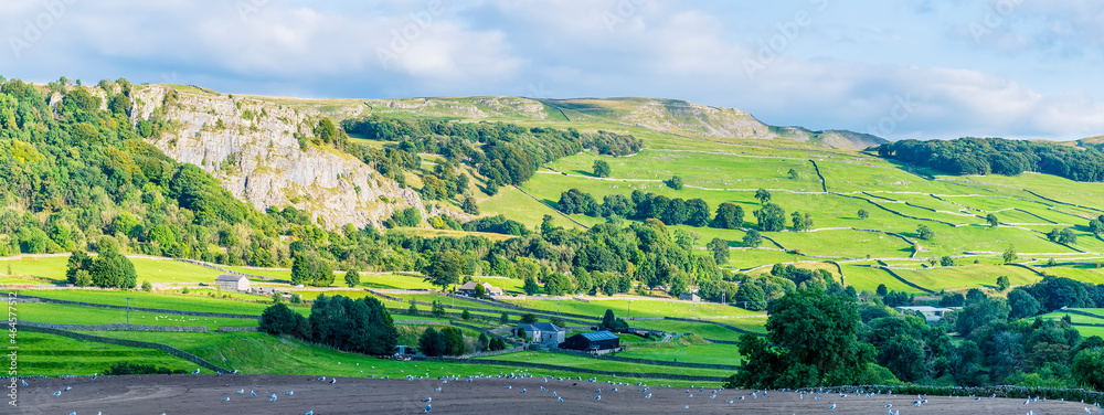 A panorama view over farmland in the River Ribble Valley near Settle, Yorkshire in summertime