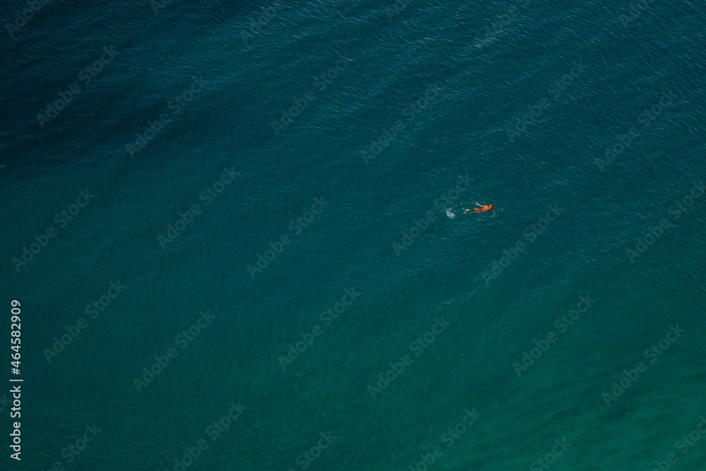 Vogelperspektive - Einsamer Schwimmer mit roter Badekappe im azurblauen Meer
