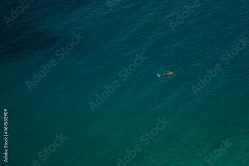 Vogelperspektive - Einsamer Schwimmer mit roter Badekappe im azurblauen Meer