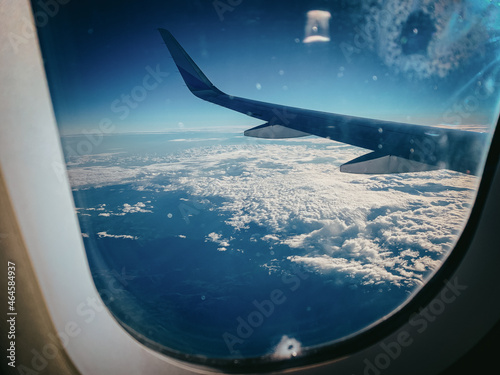 Ausblick durch ein Flugzeugfenster auf den Wolkenhimmel - Blaue Stunde