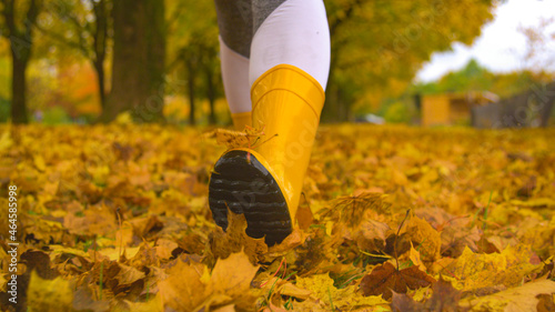 CLOSE UP, DOF: Young female wearing boots strolling around the park in autumn.