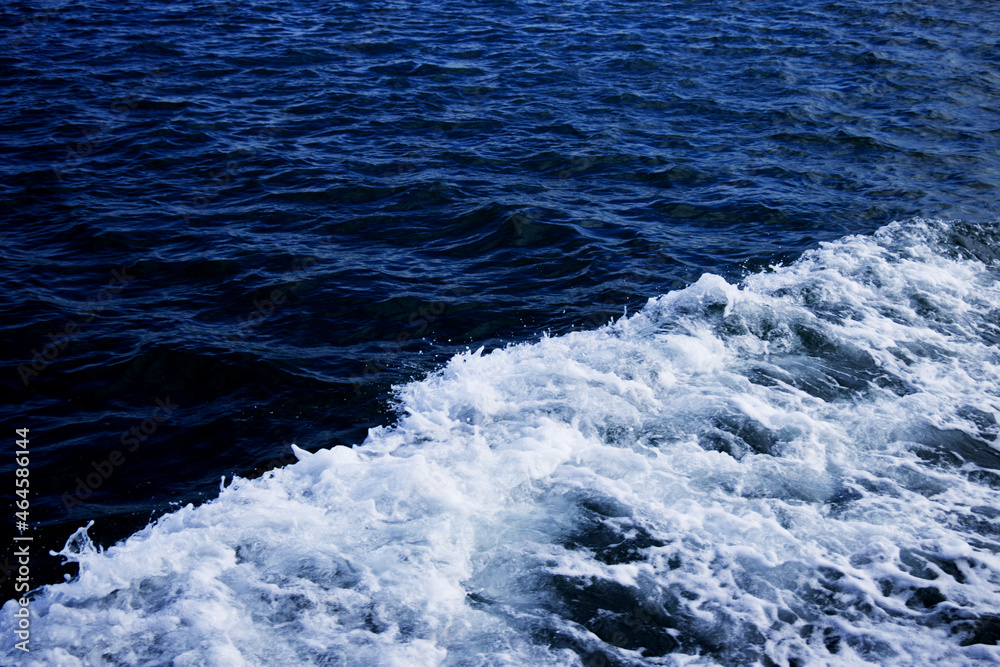 Fototapeta premium White foam wave in a dark blue sea