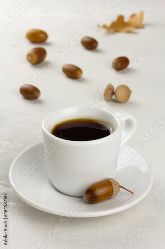 Acorn coffee in a white cup and some acorns. Healthy no caffeine beverage